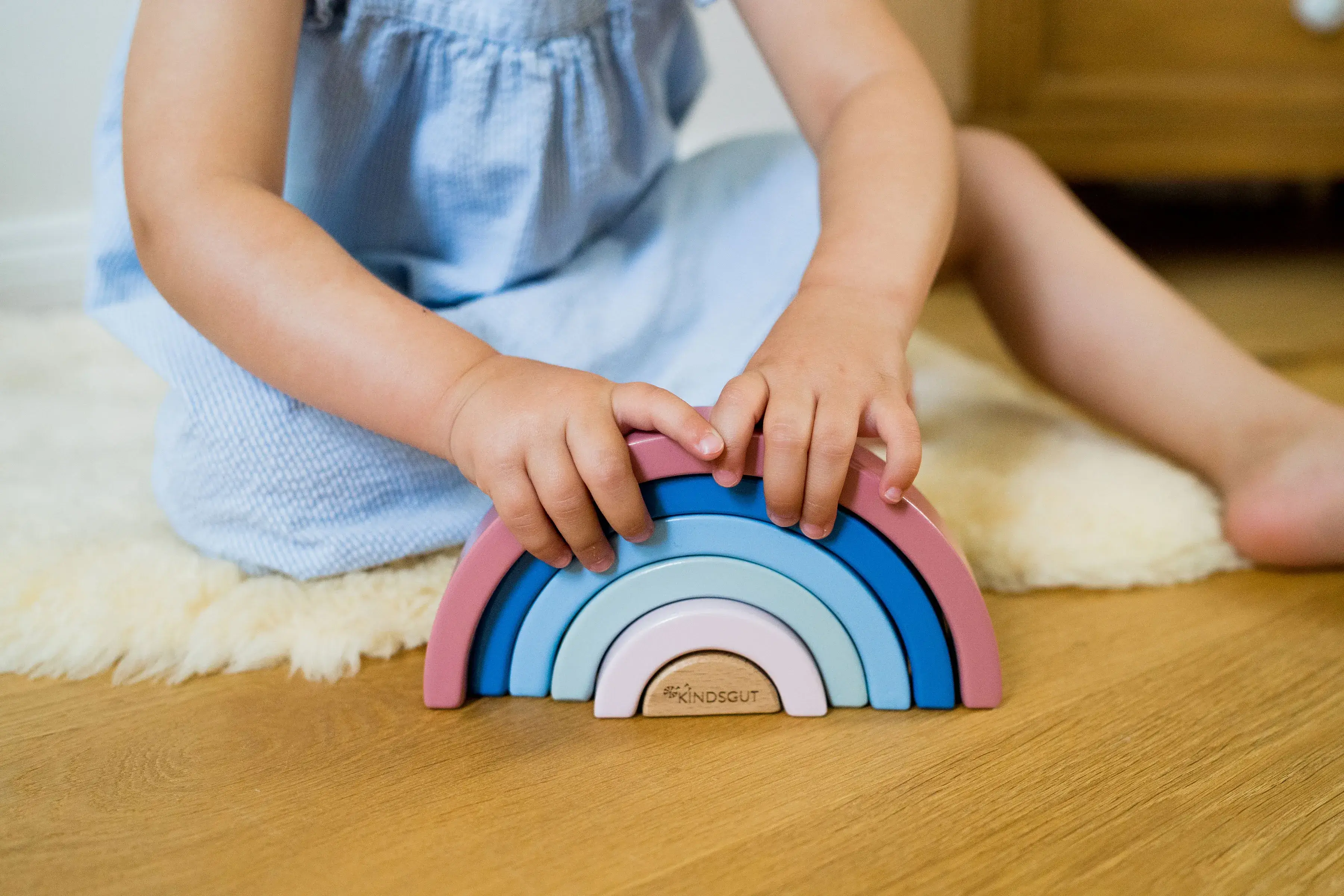 Kind spielt mit Holz Regenbogen